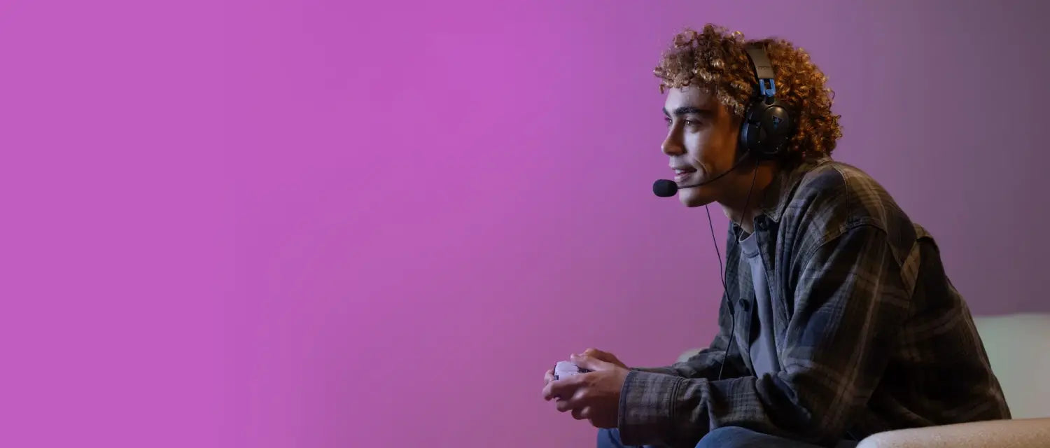 Young gamer wearing Turtle Beach headset gaming against a purple background