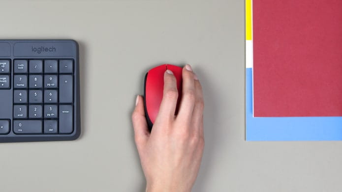 hand gripping red computer mouse