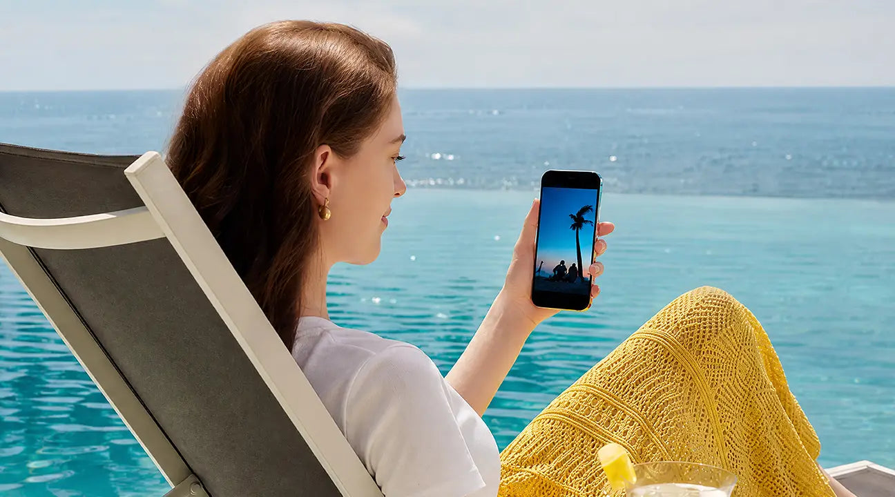 A female is sitting by the seaside with HUAWEI Pura 90s Pro Max in hand, show the 6000mah long battery life