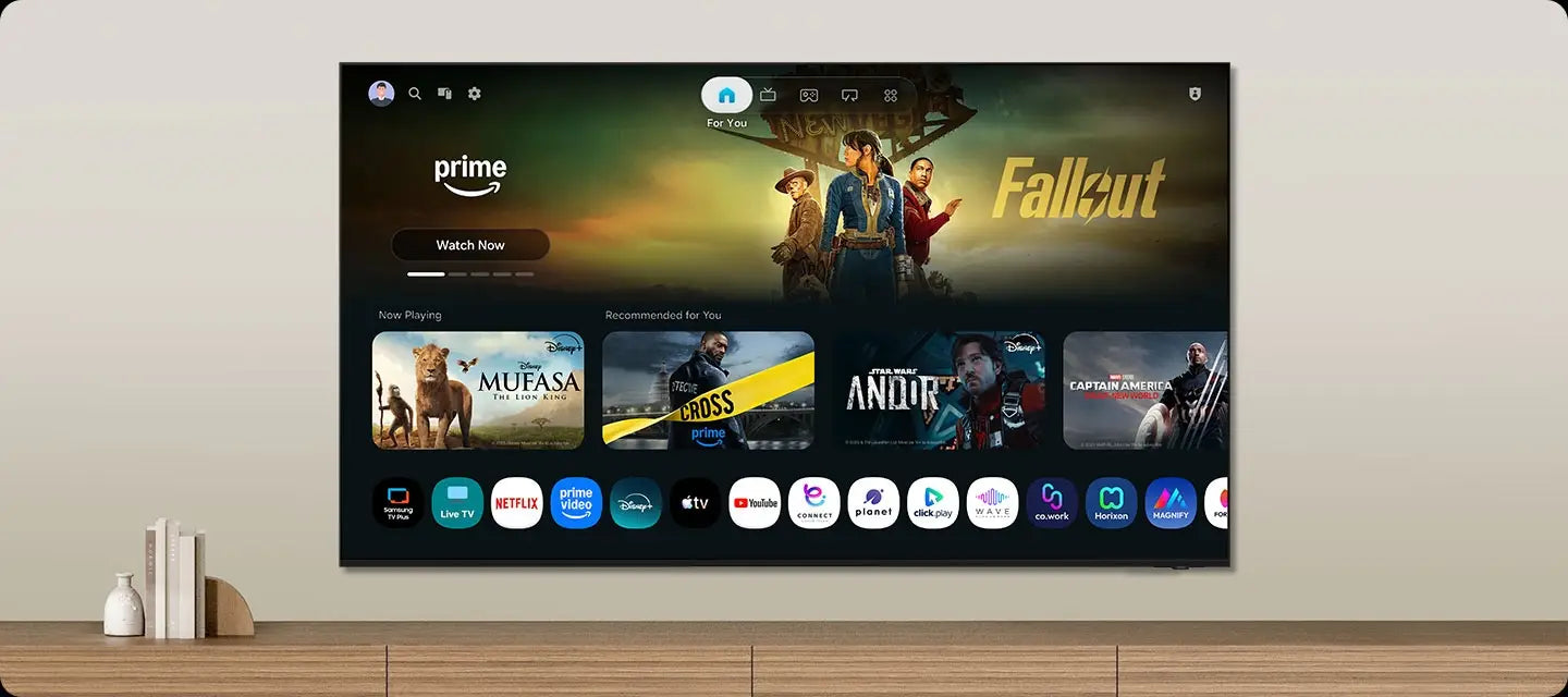One UI Tizen’s home screen, with the various apps and services available, is displayed on a TV in a living room.